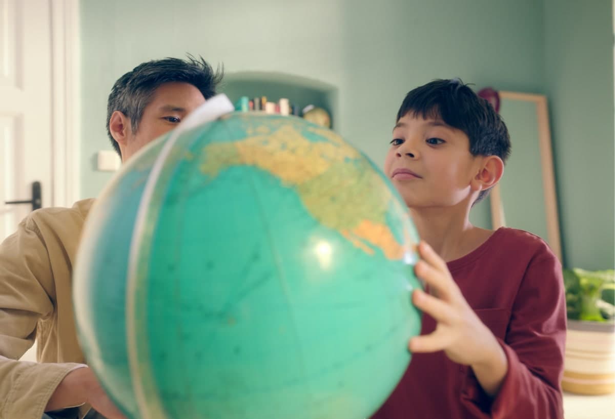 Young boy looks at globe