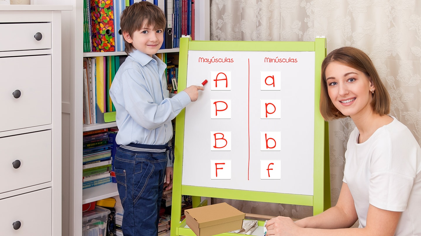 Niño mostrando las manualidades en el pizarrón a su mamá