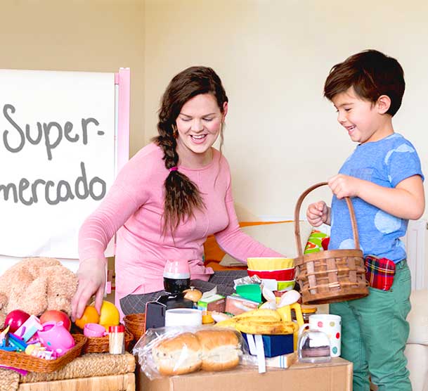 Mama y niño jugando con diversos objetos sobre una mesa.