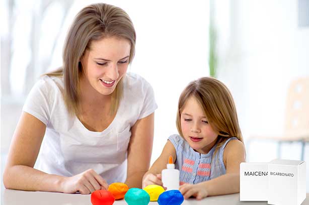 Mamá e hija realizando manualidades sobre la mesa.